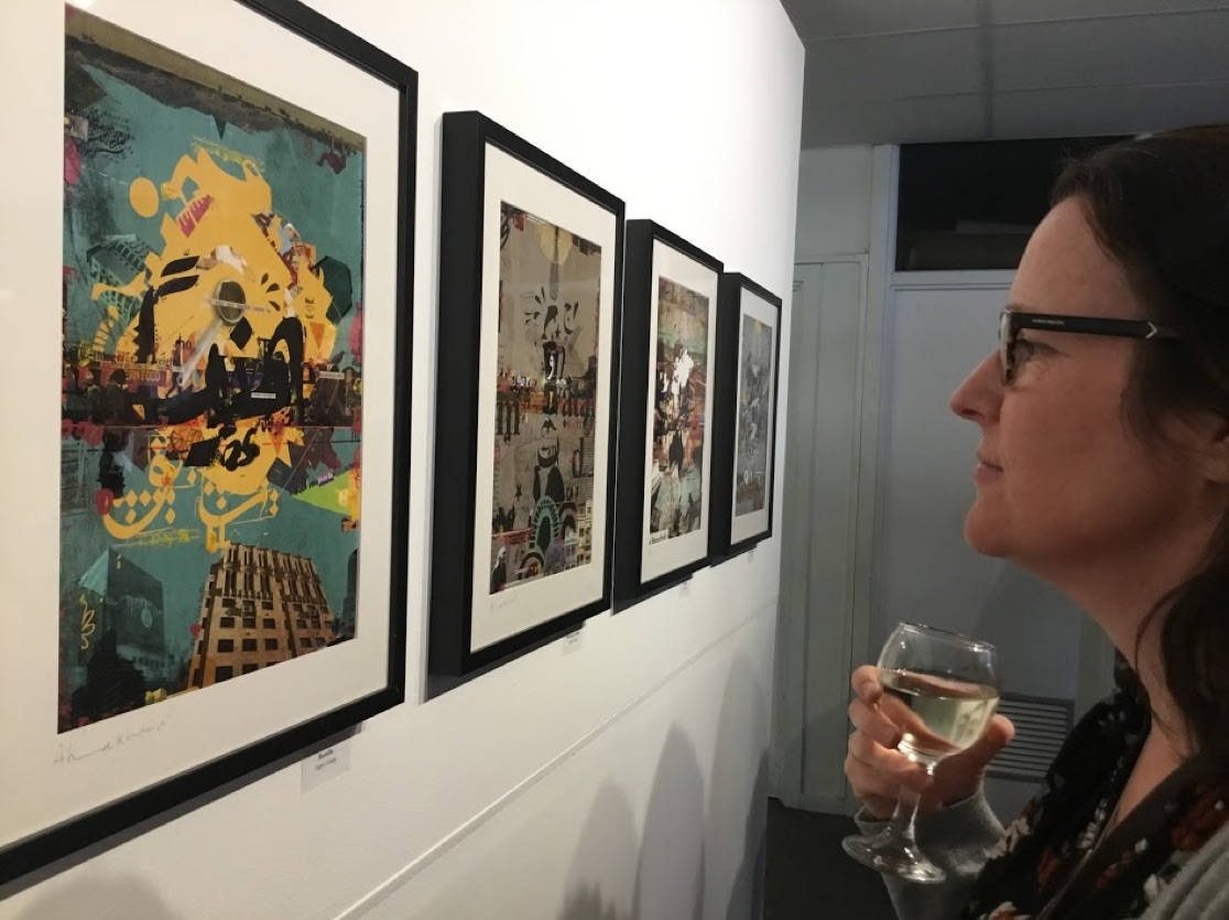 Woman holding wine and looking at aretwork