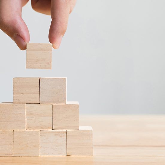 Hand arranging wood block stacking as step stair. Business concept for growth success process