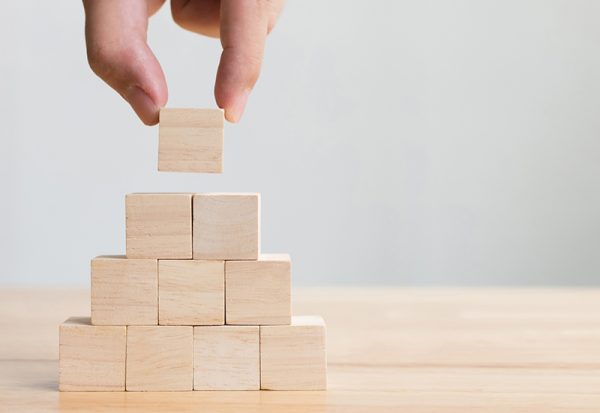 Hand arranging wood block stacking as step stair. Business concept for growth success process