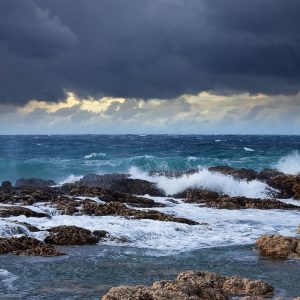Sea wave breaking against coast rock. Mediterranean area