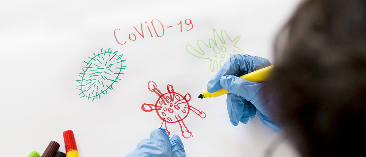 Boy wearing gloves drawing COVID-19 coronavirus