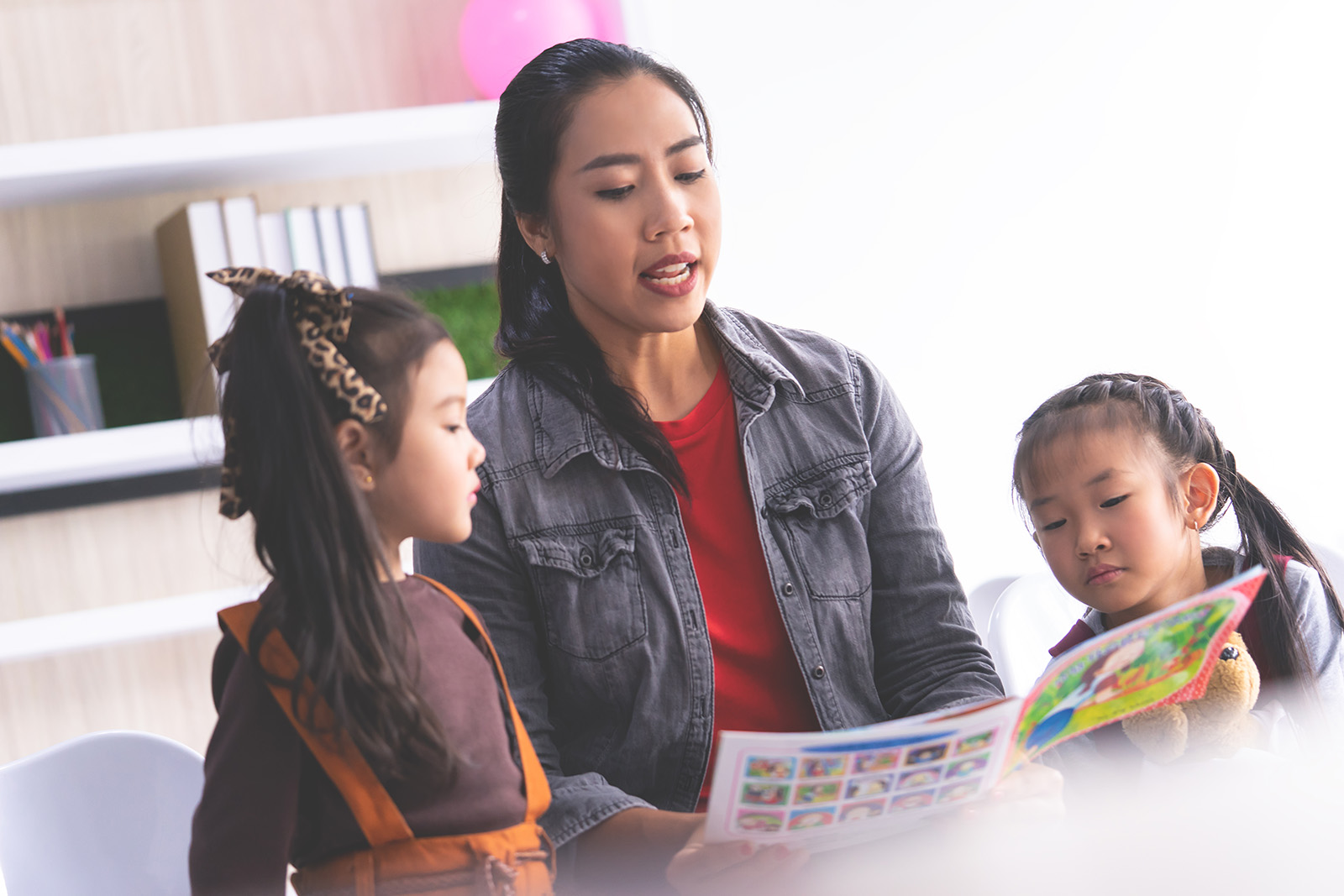 Teacher is reading story book to kindergarten students