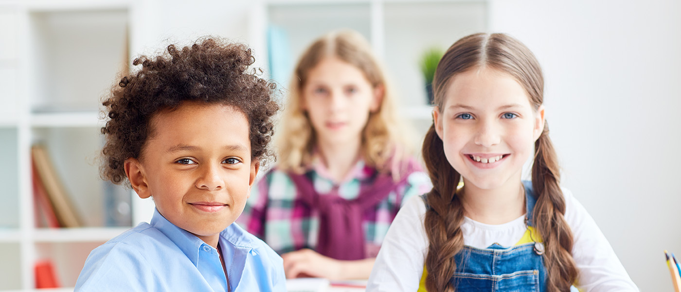 Friendly classmates reading book of tales at lesson