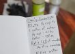 A selective focus shot of a hand holding cleaning concentrate handwritten recipe