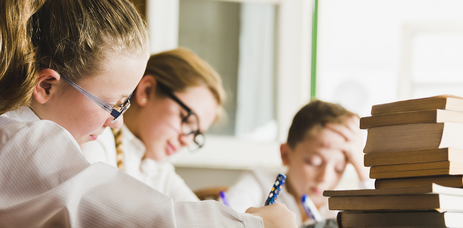 Girl studying with friends at a library desk Girl studying with friends at a library desk
