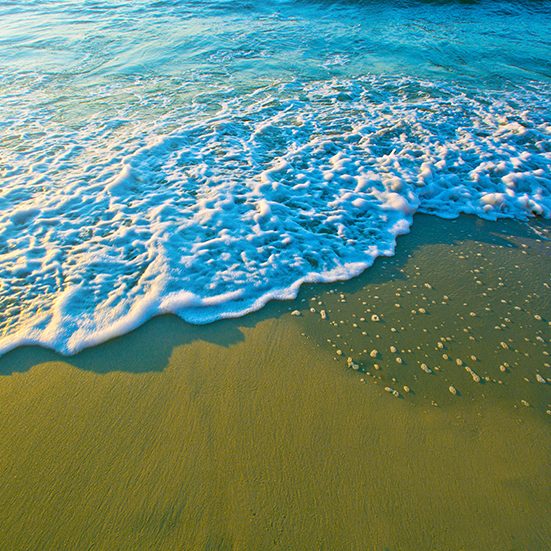 Blue sea waves on sand.