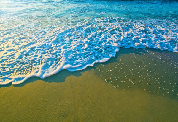 Blue sea waves on sand.