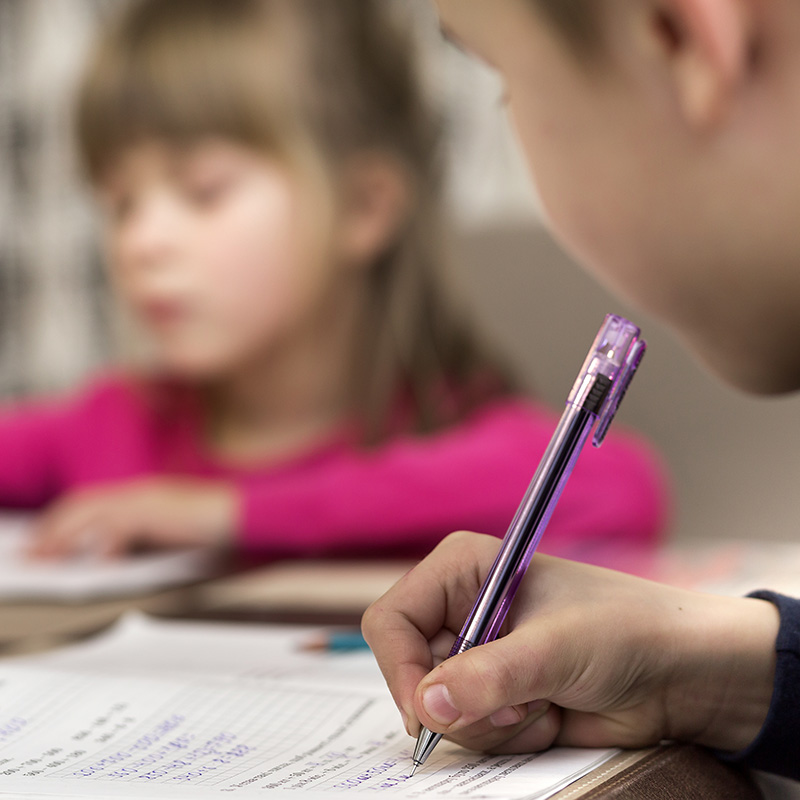 Two cute young children, boy and girl, brother and sister doing homework, writing and drawing at home on blurred background. Art education, creativity and children activities concept.
