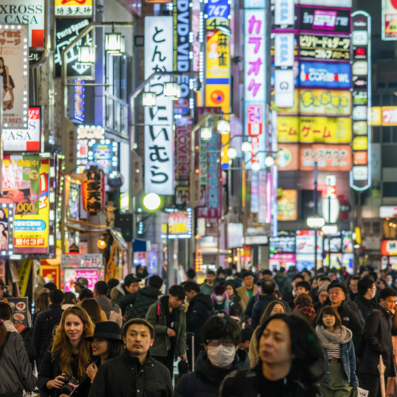 People walking around at night near Shinjuku in Tokyo