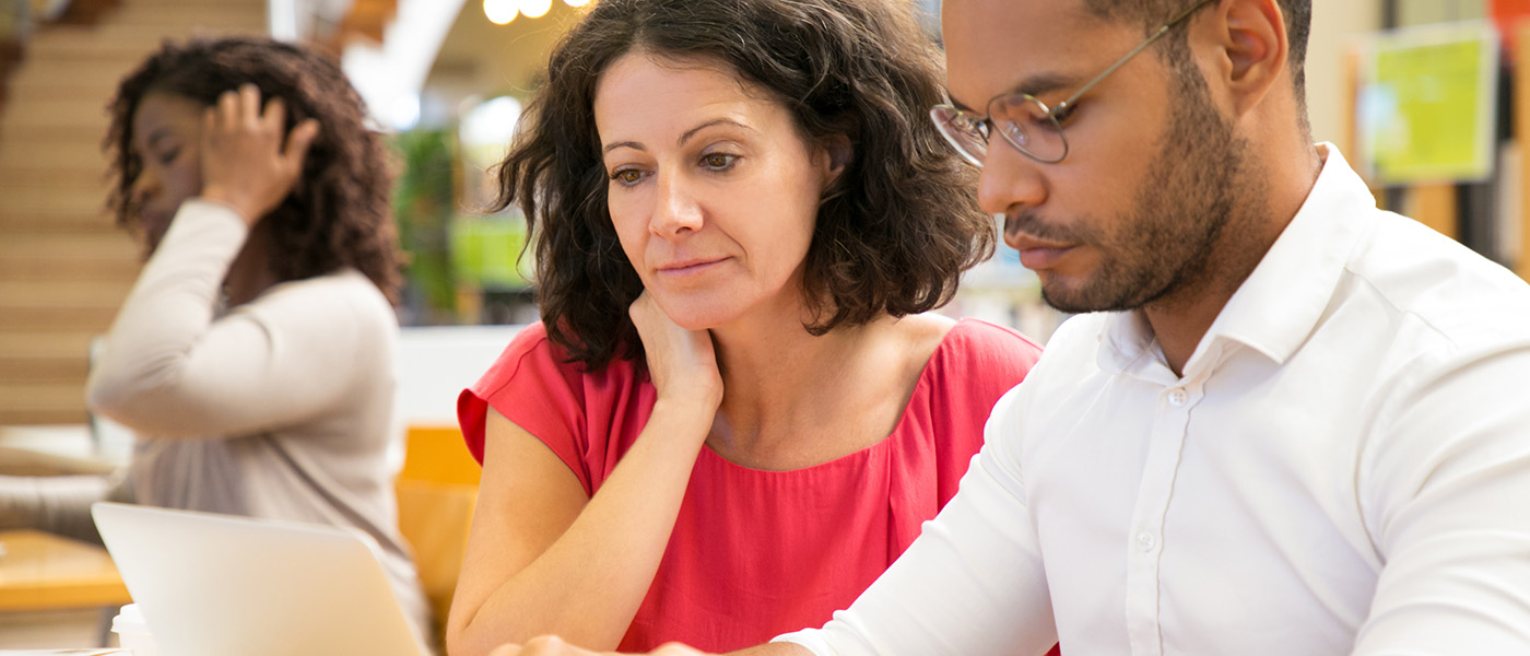 Concentrating people reading information from laptop.