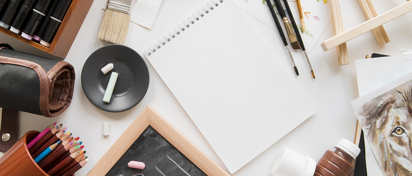 Top down view of assorted art supplies on desk