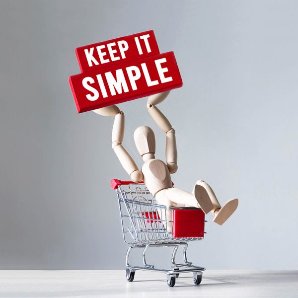 Wooden man hold a red wooden block with word KEEP IT SIMPLE ,concept Wooden man hold a red wooden block with word KEEP IT SIMPLE