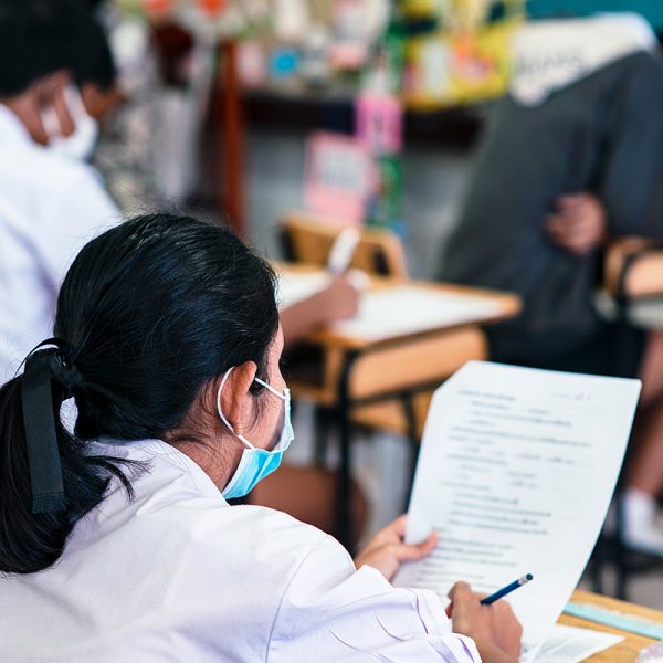Students wearing mask for protect covid-19 and doing exam in classroom with stress