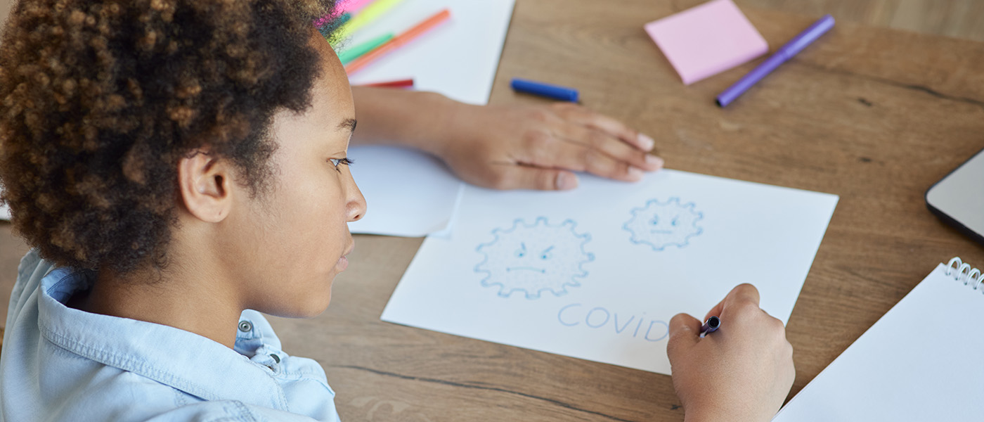 Mixed race teen schoolgirl drawing Covid19 on paper with colorful markers while spending time at home during quarantine Mixed race teen schoolgirl drawing Covid19 on paper with colorful markers while spending time at home during quarantine. Online education and distance learning for kids