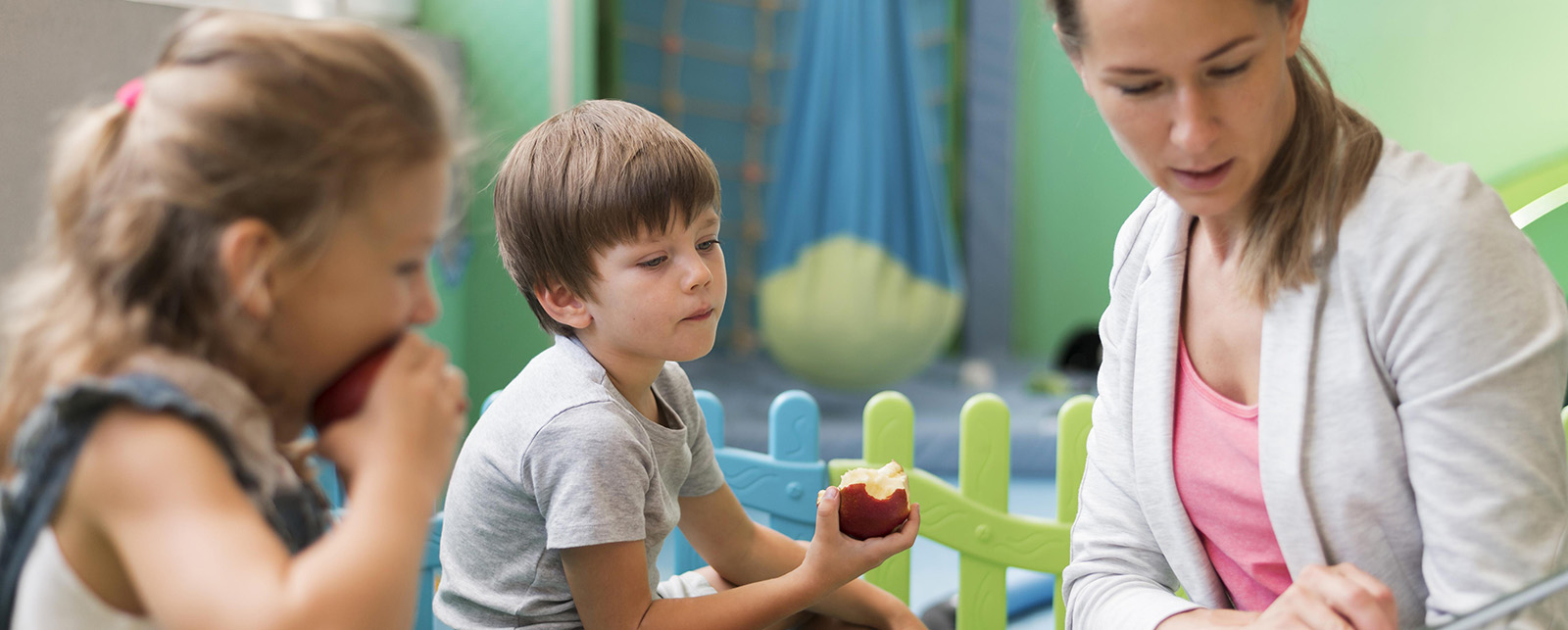 Teacher reading a book to two children