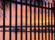 image of sunset through fence