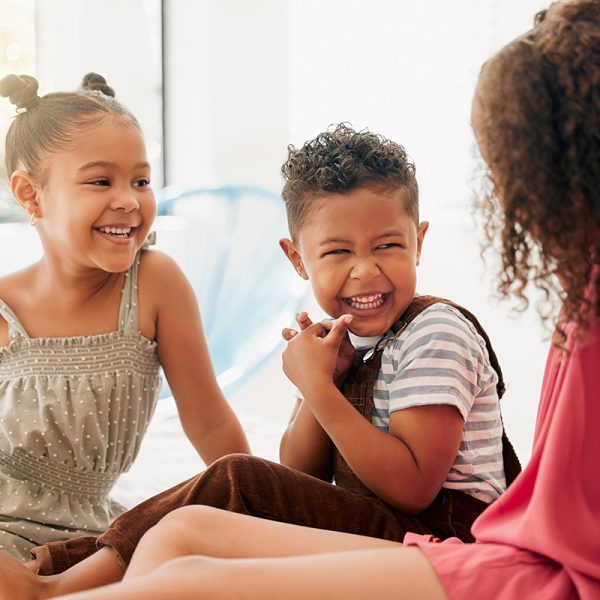 Happy, cheerful and laughing children sitting together and havin